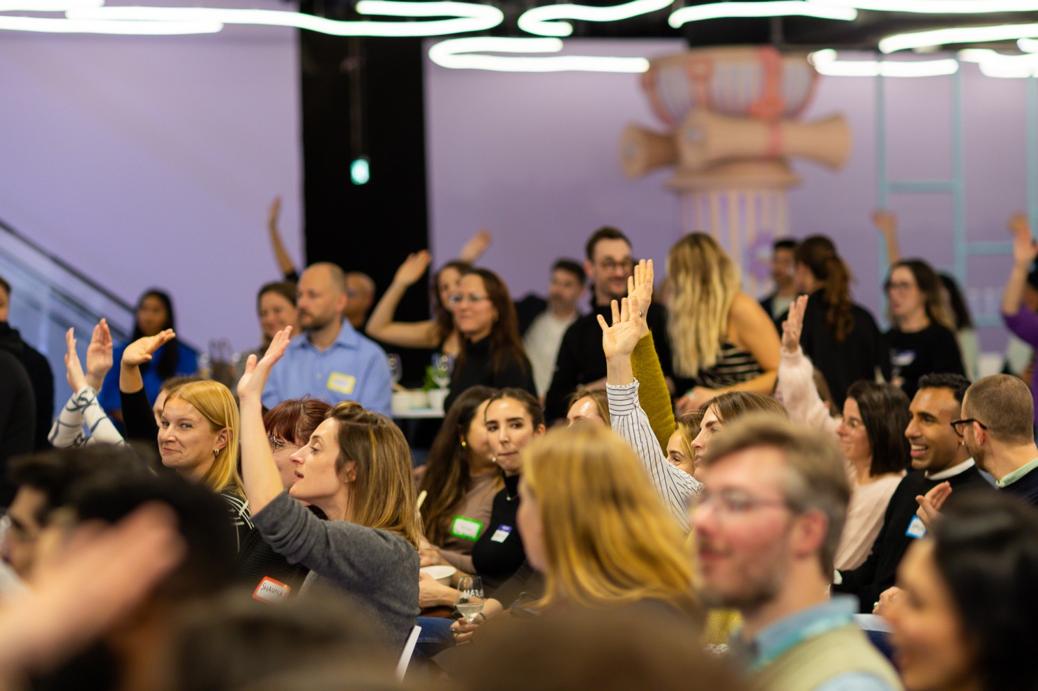 A Talent Crunch event in full swing — dozens of attendees with hands raised, engaged and answering a live question.
