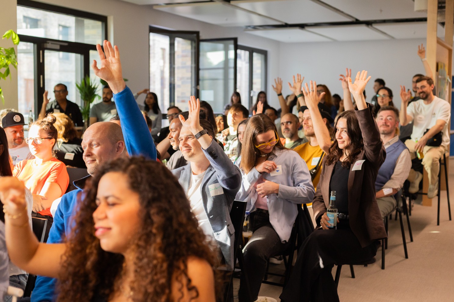 Talent Crunch audience with hands raised during a session